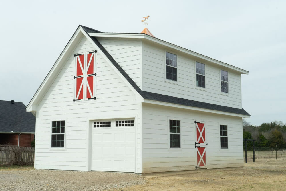 A large white barn from Ulrich with red accents.